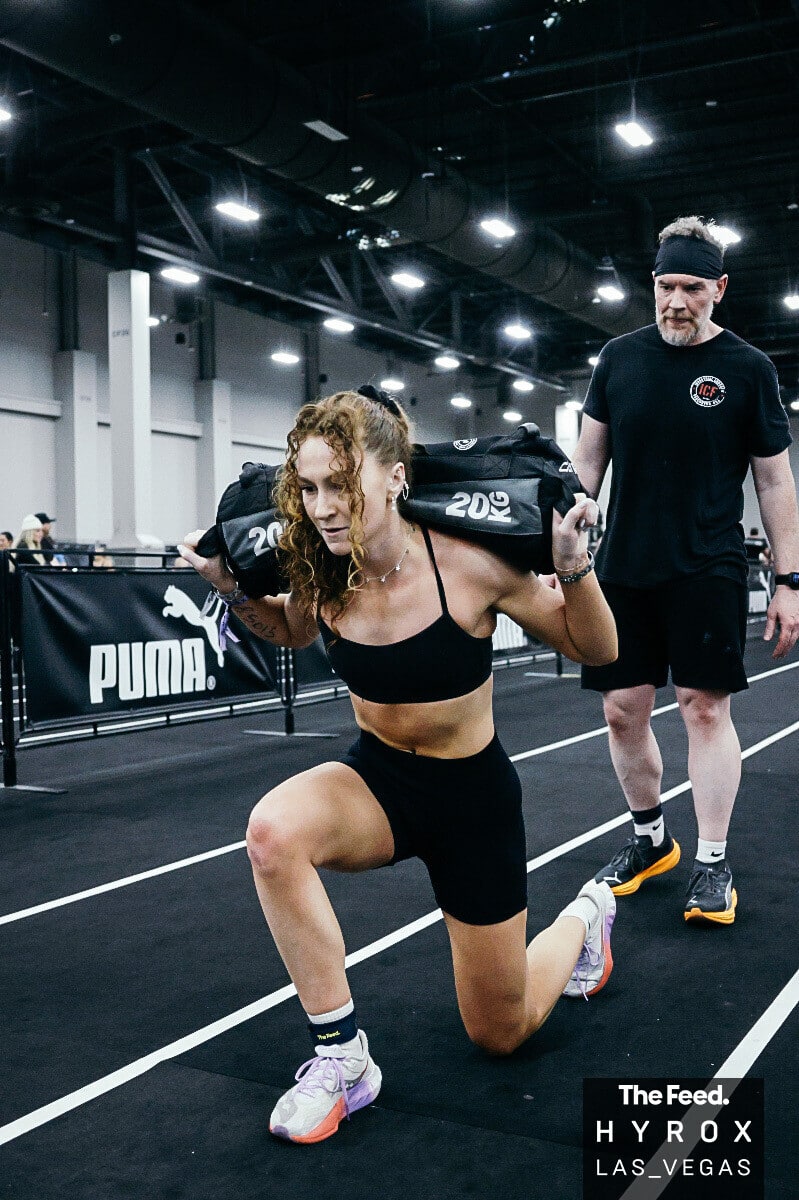 Infinity Fitness AZ coach completing sandbag lunges during a HYROX Las Vegas competition